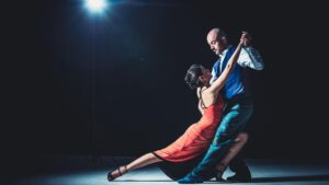 A man and woman performing a tango dance on stage.