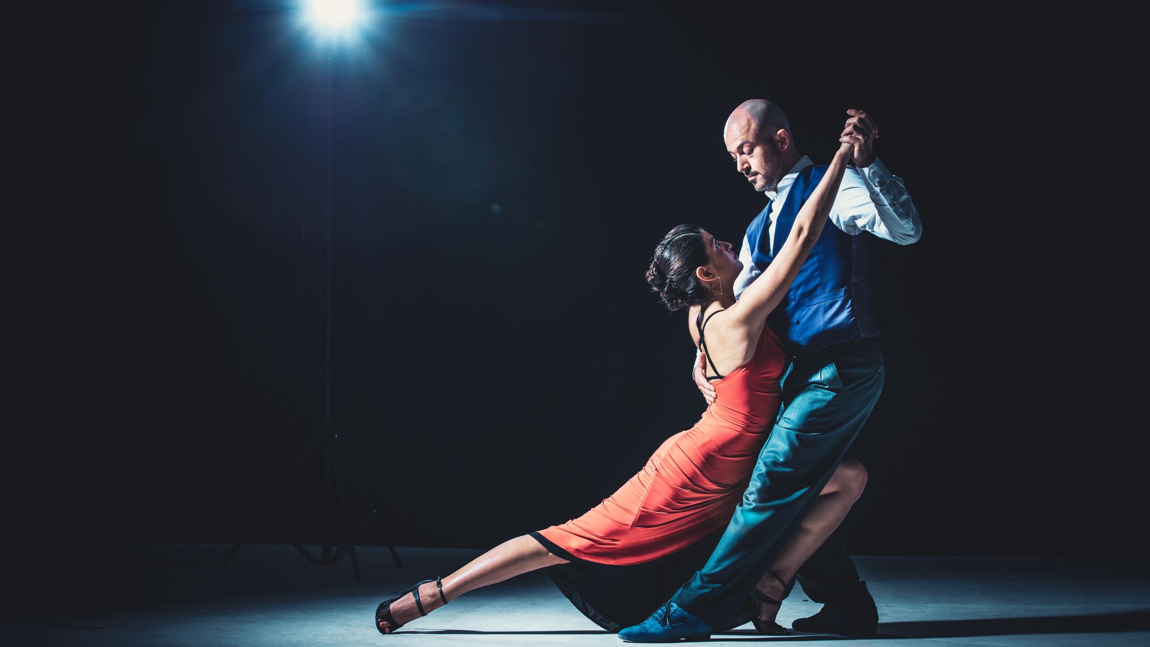 A man and woman performing a tango dance on stage.