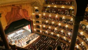 Large birds-eye-view of a intricately decorated historic performance venue with balconies and a large stage.